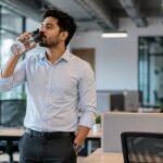 Pani Kam Peene Ke Nuksan Aur Daily Hydration Tips showing an office worker taking a water break during work